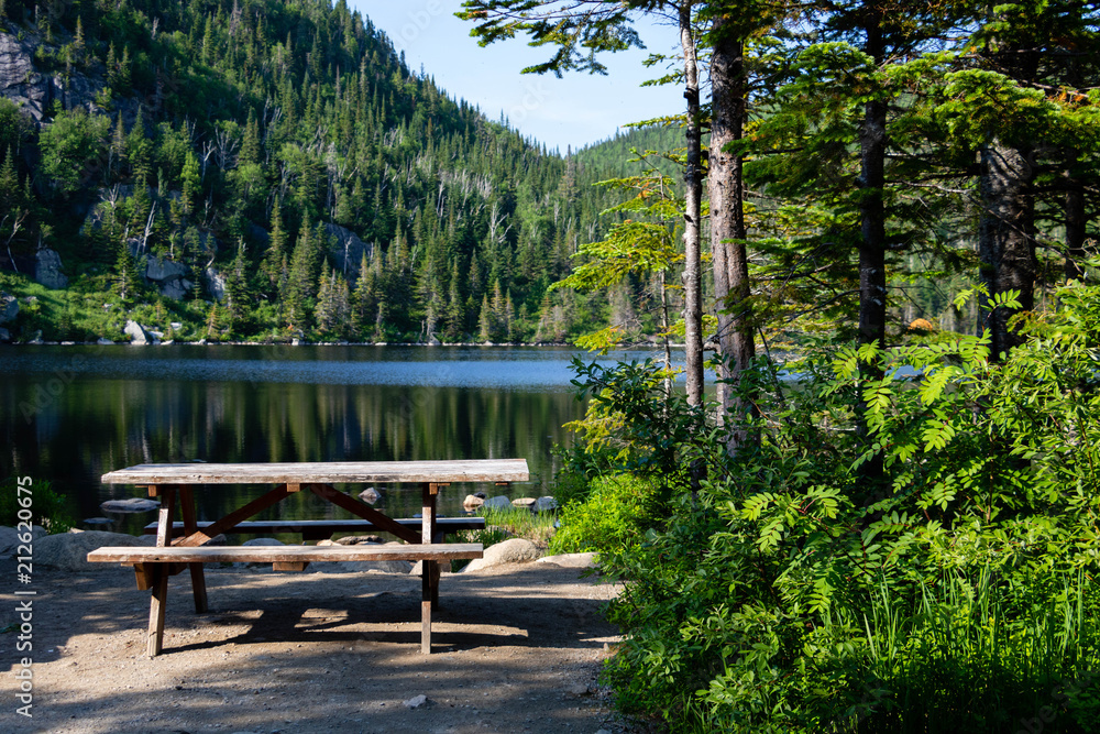Fototapeta premium A bench near a lake in the Grands-Jardins national park in the Charlevoix region in Canada.
