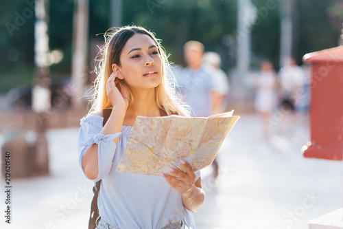 Young beautiful female traveler lost in the city photo