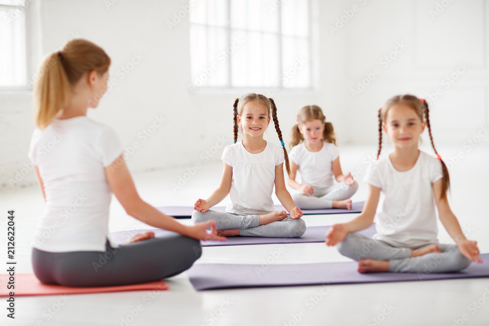 children practicing engaged in gymnastics and yoga with teacher. children practicing engaged in gymnastics and yoga with teacher.