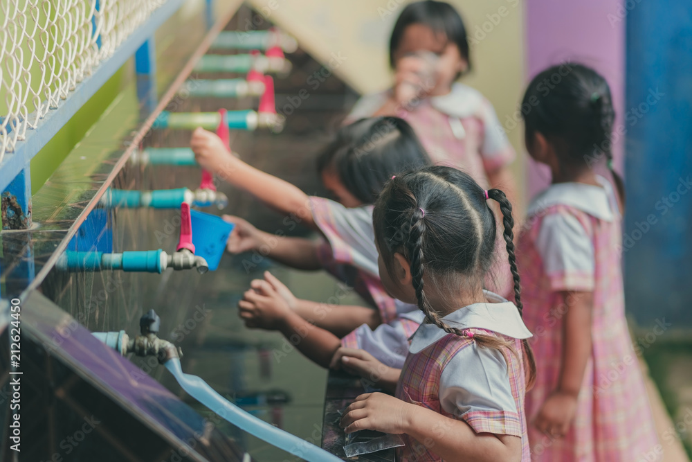 Obraz premium Students drinking water from the faucet after lunch.