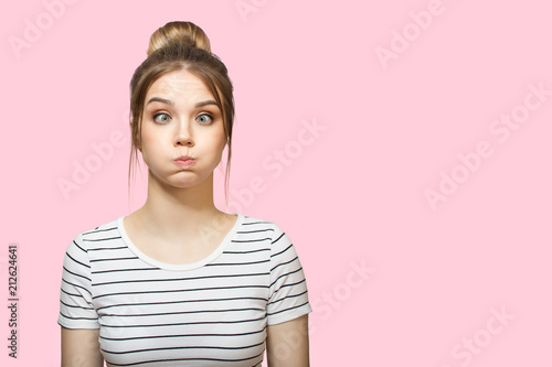 Fényképezés funny woman blowing cheeks. pink background