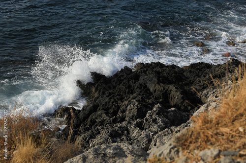 Waves break against rocks of the medieval castle town of Monemvasia, Aegean sea, Peloponnese, Greece, June 2018.