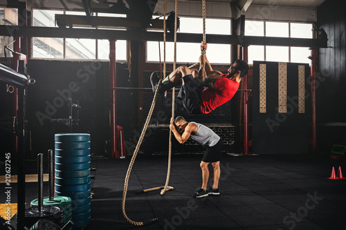 Two men doing rope climbing exercise