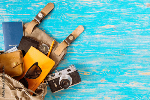 backpack with stuff. travel concept. passport money sunglasses on blue wooden background. copy space