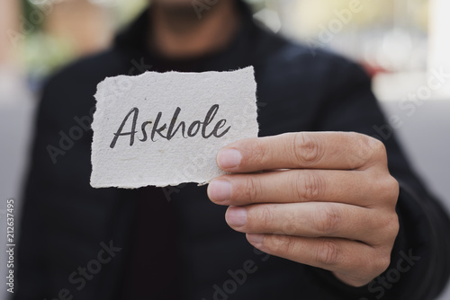 Foto man showing a note with the word askhole in it