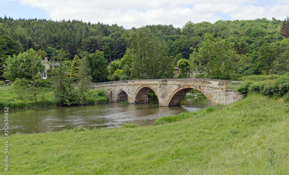 Old arched stone bridge across the River Derwent at Kirkham in North Yorkshire, England