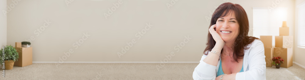 Banner of Middle Aged Woman Relaxing Inside Empty Room With Moving Boxes Banner of Middle Aged Woman Relaxing Inside Empty Room With Moving Boxes