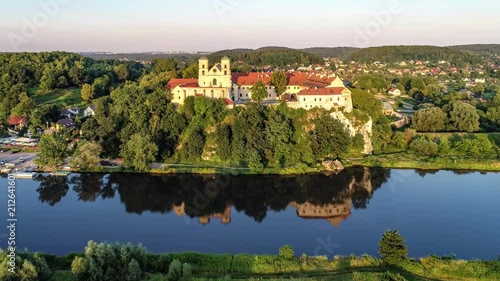 Tyniec near Krakow, Poland. Benedictine abbey, monastery and church on the rocky cliff and its reflection in Vistula River. Aerial approaching video at sunset photo