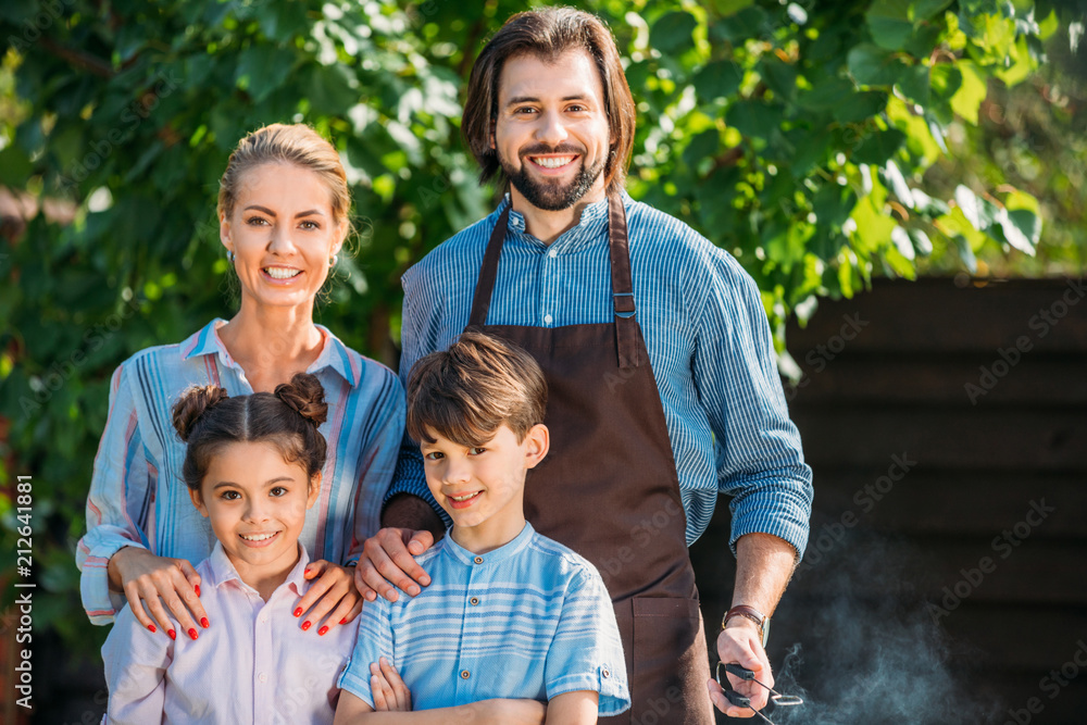 portrait of smiling family looking at camera on backyard on summer day portrait of smiling family looking at camera on backyard on summer day