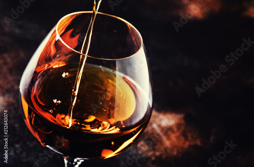 Cognac Pour Into Glass, Vintage Brown Background, Selective Focus