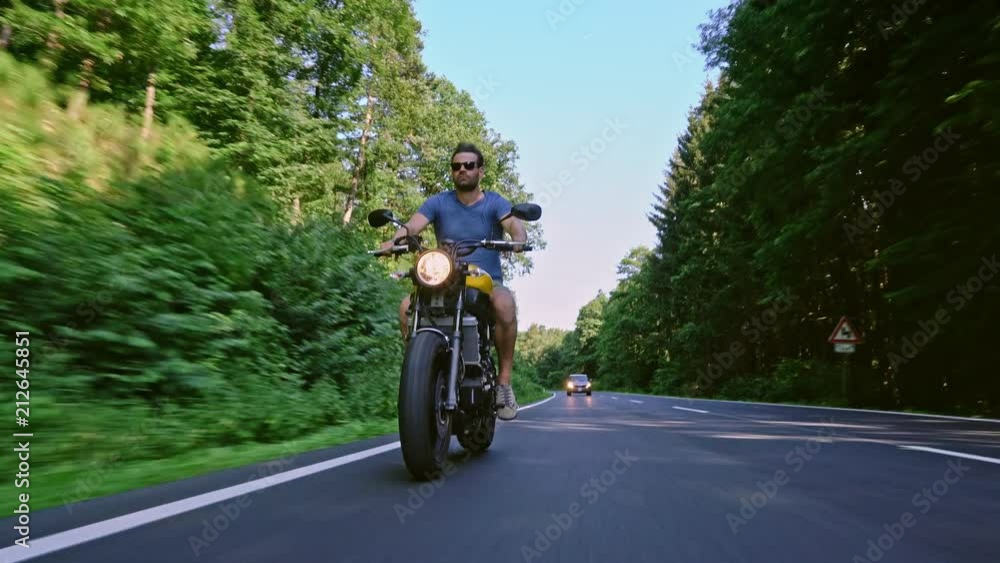 modern custom scrambler motorbike on a forest road riding. having fun driving the empty road on a motorcycle tour journey. 4k Video modern custom scrambler motorbike on a forest road riding. having fun driving the empty road on a motorcycle tour journey. 4k Video