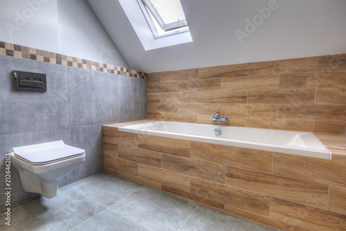 New bathroom interior in the house. Gray concrete tiles with wooden decor.