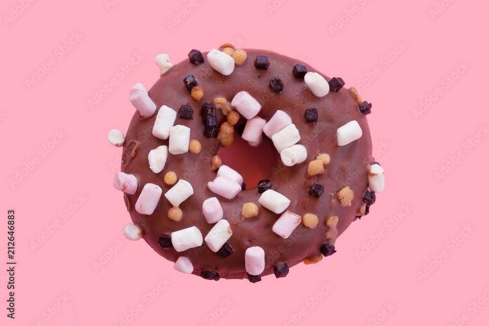 Chocolate doughnut with small marshmallos on a pink bankground Chocolate doughnut with small marshmallos on a pink bankground
