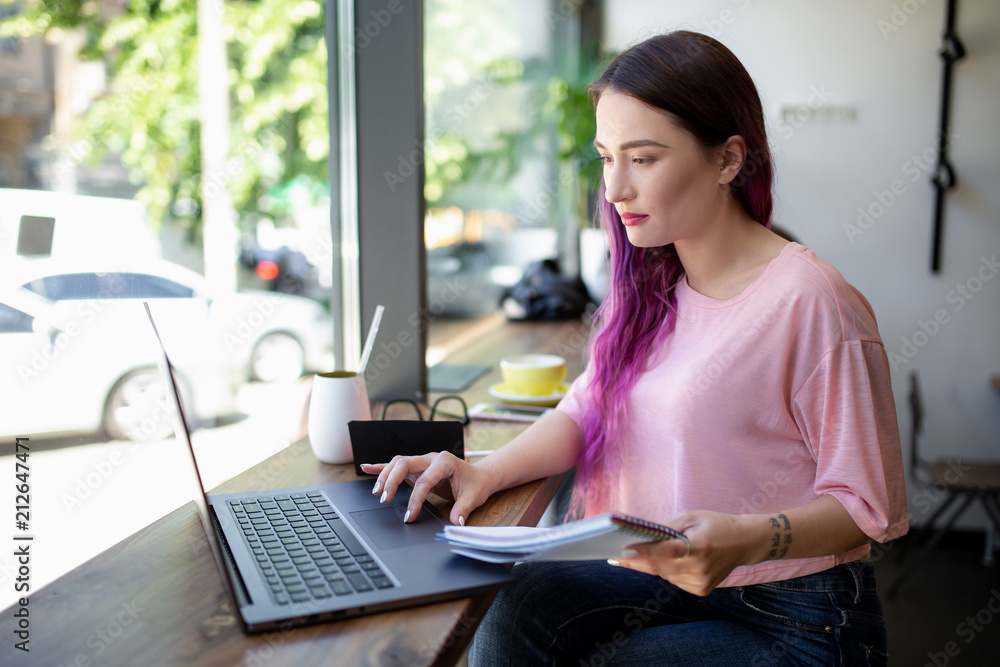 Side view of young businesswoman sitting at table in coffee shop Side view of young businesswoman sitting at table in coffee shop