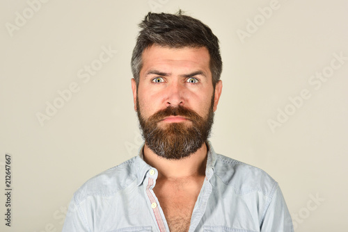 Serious bearded man. Man with long beard and mustache. Feeling and emotions. Close Up portrait of seroius bearded man. Emotions. Feelings. Facial expressions concept. Grey background.
