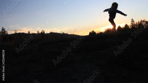Wallpaper Mural Silhouette of little girl spinning near lake at sunset. Torontodigital.ca