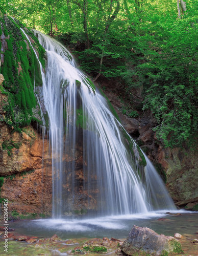 Big waterfall at the green forest in europe