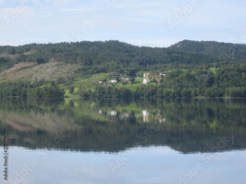 Reflection of houses and trees in crystal clear lake water...Norway