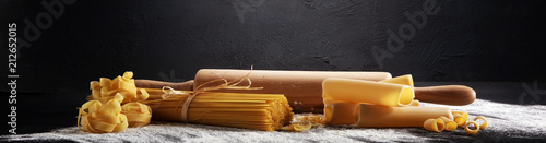 Various mix of pasta on grey rustic background. Diet and food concept.