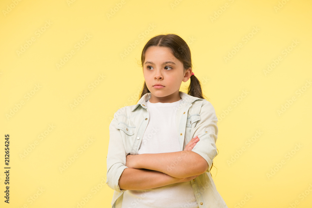 I do not want to see you. After dispute. Girl serious face offended yellow background. Kid unhappy looks strictly. Girl folded arms on chest looks serious. Sensitive girl not want to talk I do not want to see you. After dispute. Girl serious face offended yellow background. Kid unhappy looks strictly. Girl folded arms on chest looks serious. Sensitive girl not want to talk
