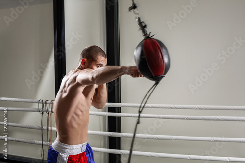A boxer wearing gloves in the training hall. Boxer kick in the gym. photo