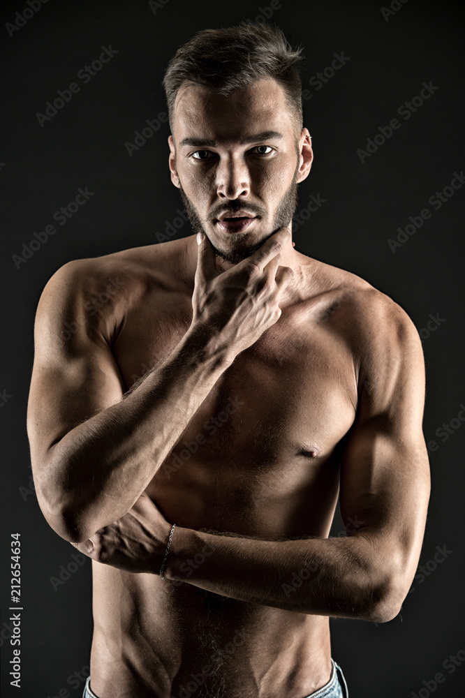 What if I will show you my muscles. Man thoughtful face looks attractive black background. Athlete sexy muscular body on confident face. Man muscular torso tense muscles veins touch chin while think