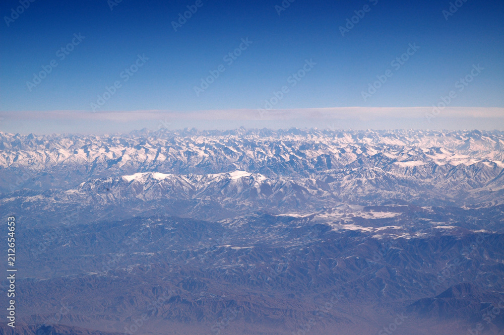Mountains with snowy peaks on blue sky, aerial view. Planet earth natural landscape. Travel around world. Environment protection and ecology. Earth day is world birthday