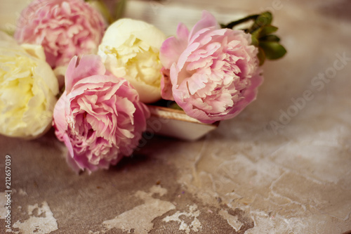 Fresh pink peonies flowers on aged wooden background. Selective focus. Toned image.