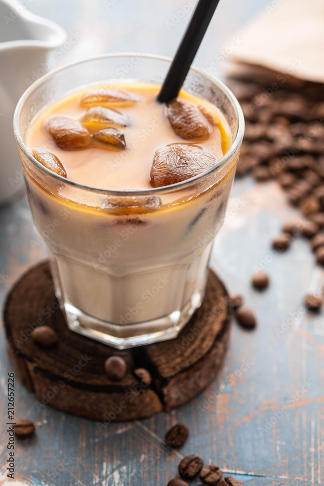 Cold coffee glass with ice cubes on wooden table background. Ice coffee. Copy space. Cold coffee glass with ice cubes on wooden table background. Ice coffee. Copy space.