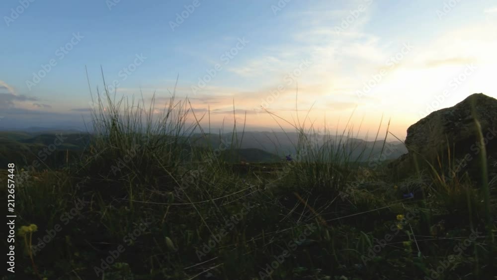Mountain sunset over the peak rock. Dark key sunset light in the mountains parallax rocks rock grass Mountain sunset over the peak rock. Dark key sunset light in the mountains parallax rocks rock grass