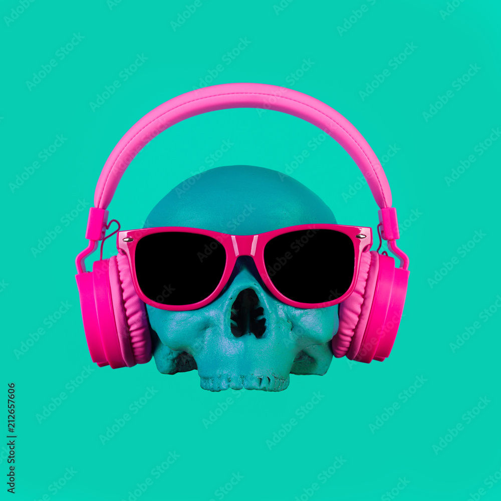 Skull in pink headphones and glasses on a turquoise background. Fashion minimal art. Skull in pink headphones and glasses on a turquoise background. Fashion minimal art.