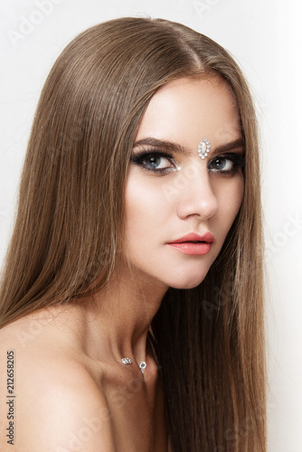 Close-up portrait of beautiful woman with bright makeup. Fashion shiny highlighter on skin, gloss lips.