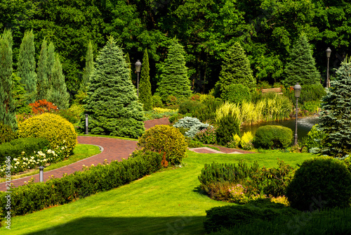 flowers and flower beds and paths with trees in a landscape park