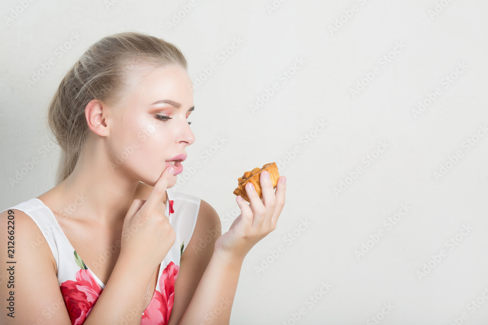 Pleased blonde woman with natural makeup holding savory dessert with nuts. Space for text Pleased blonde woman with natural makeup holding savory dessert with nuts. Space for text