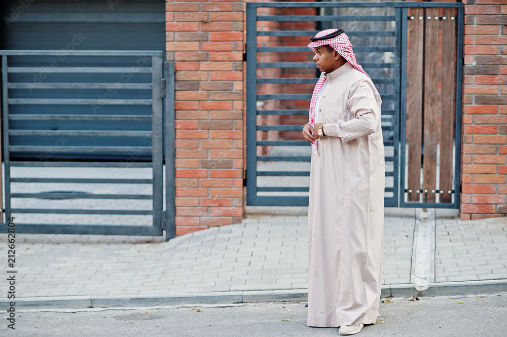 Middle Eastern arab man posed on street against modern building.