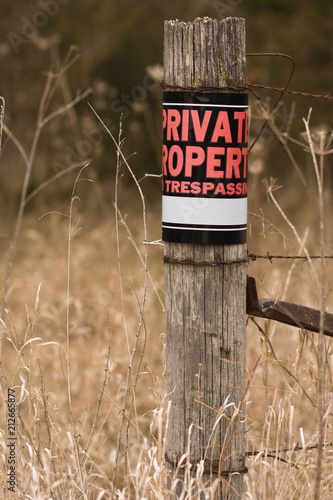 фотографія Private property - no trespassing sign on a fence post
