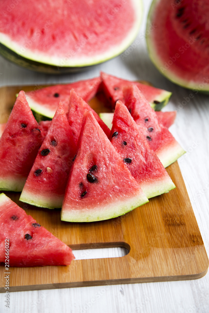 Many slices of ripe juicy watermelon on bamboo board, closeup. Side view. Selective focus. Many slices of ripe juicy watermelon on bamboo board, closeup. Side view. Selective focus.