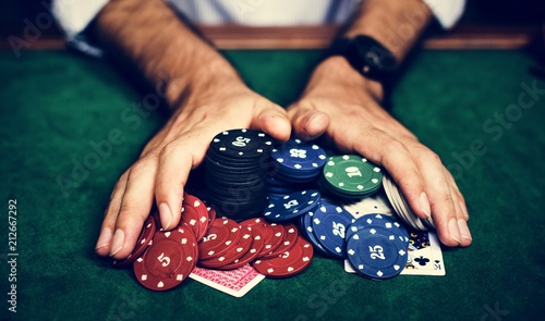 Closeup of hands with gambling tokens and card photo