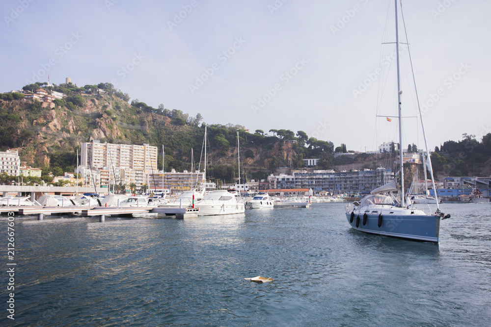 A small city harbor. Yachts and boats are moored in the port