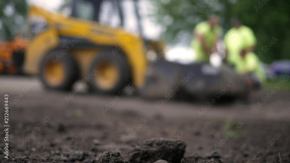 Defocused construction crew near a construction project Defocused construction crew near a construction project