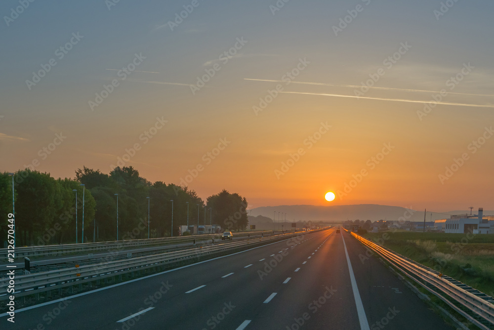 Empty motorway at sunrise, low traffic