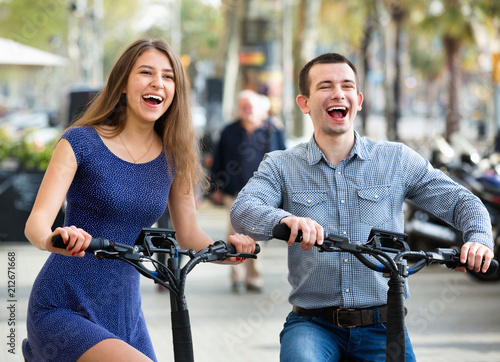 Happy young man and woman with electrkc bikes photo