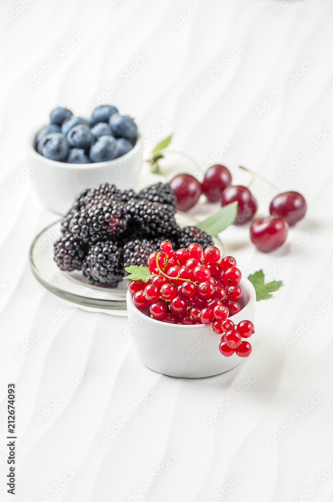 Fresh berries on a white textured table.. Fresh berries on a white textured table..