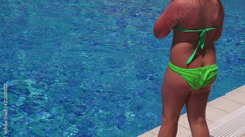 Girl jumping into the swimming pool, close up