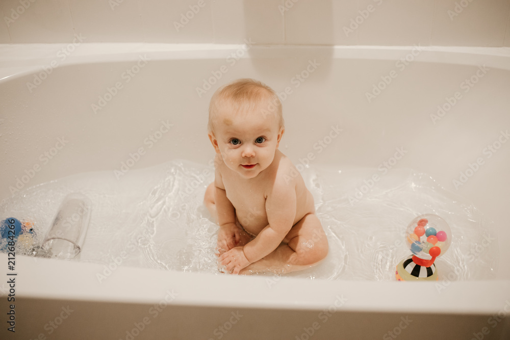 Adorable Blonde Baby Boy Playing and Smiling in the Bath Tub During Bath Time Adorable Blonde Baby Boy Playing and Smiling in the Bath Tub During Bath Time