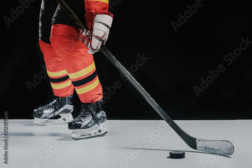 Photography low section of professional sportsman playing hockey on black