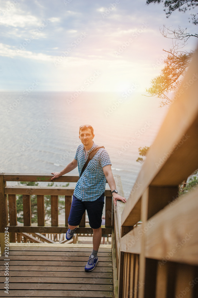 man sitting on the wooden stairs in park and smiling man sitting on the wooden stairs in park and smiling