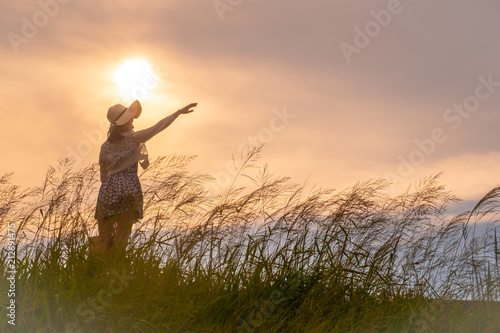 woman point to the sky in sunset