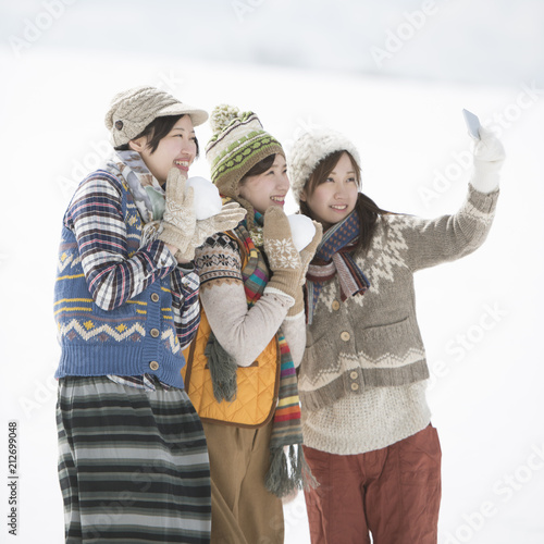 雪原で自分撮りをする3人の女性 photo