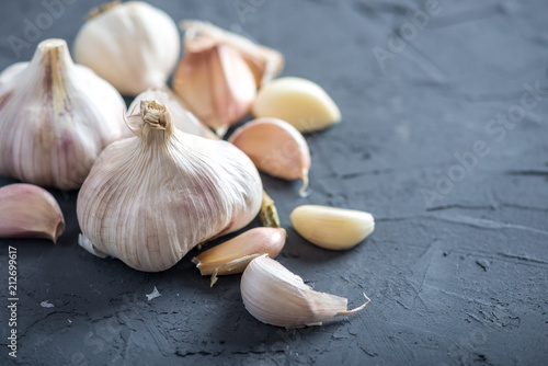 Group of garlic cloves scattered on a dark background. Important ingredient in different cuisines of the world